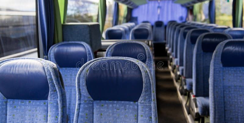 Leerer Innenraum eines Tourbusses mit blauen Sitzen für Musiker und Bands.